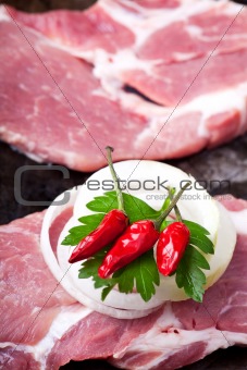 raw pork steak in a iron pan