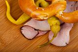 ham, pretzel and a peperoni on a wooden chopping board