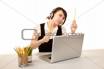 Pretty female office worker with laptop computer and headphones