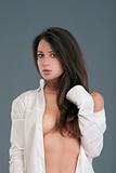 beautiful semi-nude brunette in white shirt looking at camera