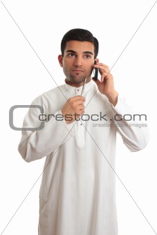 Thinking ethnic businessman on mobile phone