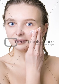 Attractive girl applying face cream