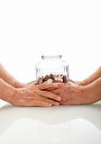 Senior hands holding a jar with coins