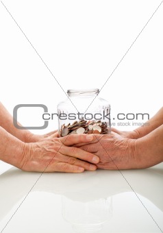 Senior hands holding a jar with coins