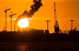Industry silhouettes, pollution and big sun