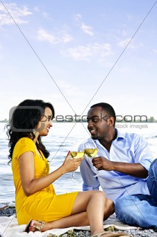 Happy couple having wine on beach