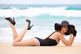 Woman in Black Swimsuit and Accessories Lying on the Beach