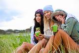 Three Friends Bundled Up With Coffee Cups in the Grass