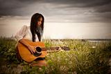Attractive Young Woman With Guitar on Beach