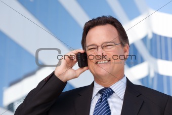 Confident, Handsome Businessman Smiles as He Talks on His Cell Phone Outdoors.