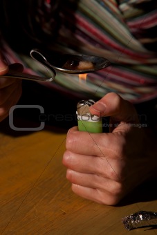 Woman cooking heroin in a bent spoon