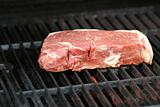 Raw steak on a BBQ grill