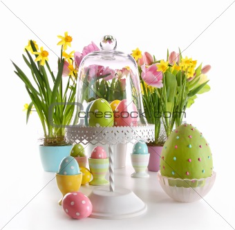 Easter eggs on cake stand with spring flowers 