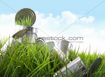 Empty food cans in grass with blue sky