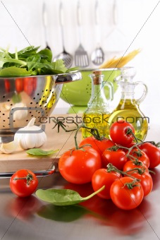 Spinach leaves in strainer with tomatoes