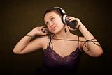 Pretty girl in funky purple outfit on green background with personal audio device