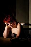 Depressed young woman alone in a dark room