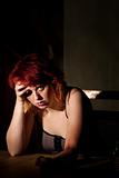 Depressed young woman alone in a dark room