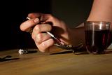 Closeup of woman's hand drawing black tar heroin into a needle