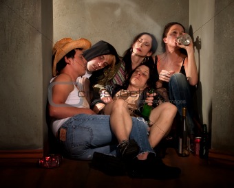 Partygoers surrounded by booze bottles in a hallway