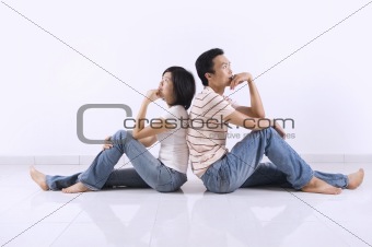 Couple sitting on floor at home.