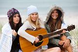 Young Women at the Beach With a Guitar