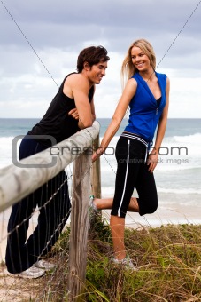 Smiling Young Couple By Fence at the Beach