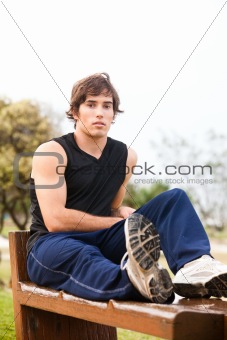 Young Man Sitting on Wooden Bench