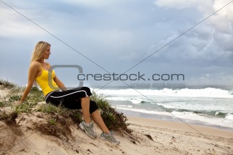 Young Woman Sitting By the Ocean