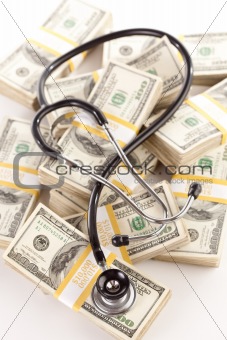 Question Mark Shaped Stethoscope Laying on Stacks of Hundred Dollar Bills with Narrow Depth of Field.
