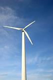 White wind turbine in front of blue sky