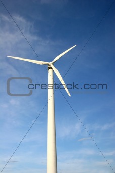 White wind turbine in front of blue sky