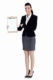 Full length of business woman pointing at the clipboard