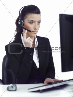 Busy woman seriously hearing the customer talk in headset