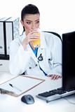 Doctor drinking a glass of juice at her workplace