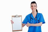 Portrait of young nurse pointing blank clipboard