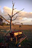 old plough on farm at sunset