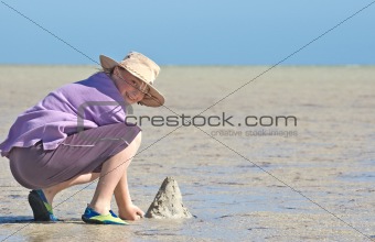 teenager making sandcastles on the beach
