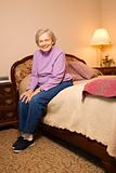 Elderly Caucasian woman in bedroom.