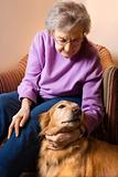 Elderly Caucasian woman petting dog. 
