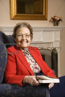 Elderly Caucasian woman holding a book.