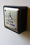 Metal door entrance button for handicapped people.