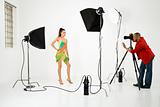 Young female model being photographed by male photographer.