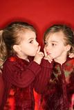 Female children twins with fingers up to lips.