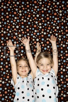 Female children twins  with arms raised.