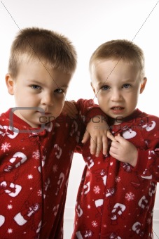 Male twin children leaning on eachother.