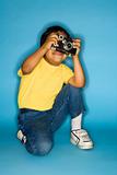 Male child kneeling with camera.