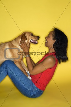 Adult female petting dog.