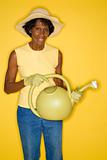 Mature adult female holding watering can.