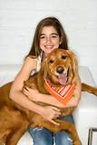 Female adolescent  holding dog.